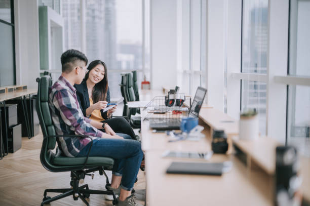 side view  Asian Chinese female colleague explaining to her trainee  having discussion at office workplace side view  Asian Chinese female colleague explaining to her trainee  having discussion at office workplace south east asia choicepix stock pictures, royalty-free photos & images