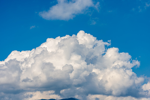 Beautiful storm clouds, cumulus clouds or cumulonimbus against a clear blue sky. Photography, Full frame. Italian Alps, Italy, Europe.