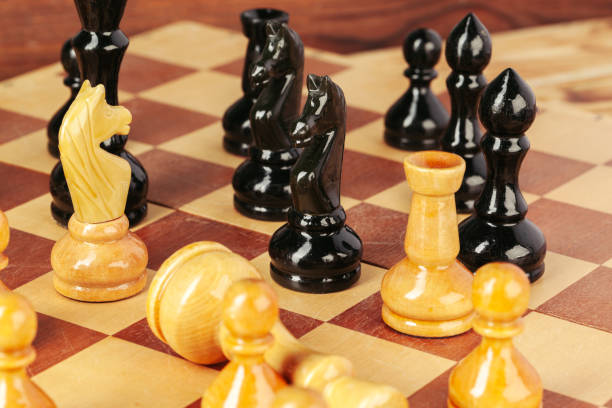 istock Chess pieces on a wooden chessboard against a dark background 1331471718