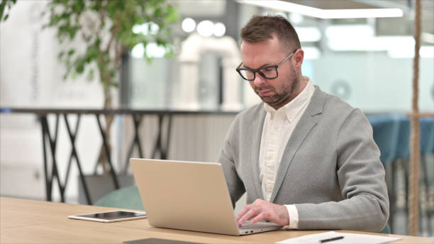 istock Casual Young Man Working on Laptop in Office 1331472851