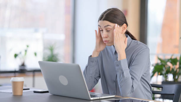 istock Young Latin Woman with Headache at Work 1331473676