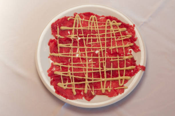 Beef Carpaccio with Mayonnaise Sauce in Classic Cipriani Style on a White Plate