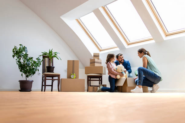 Happy modern family moving into new house and unpacking boxes together. Happy modern family moving into new house and unpacking boxes together. skylight stock pictures, royalty-free photos & images