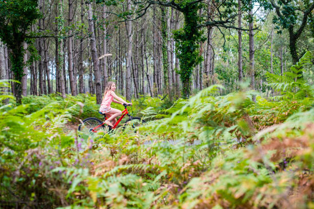 istock young girl riding a bicycle on a cycle path through a beautiful forest 1331485612