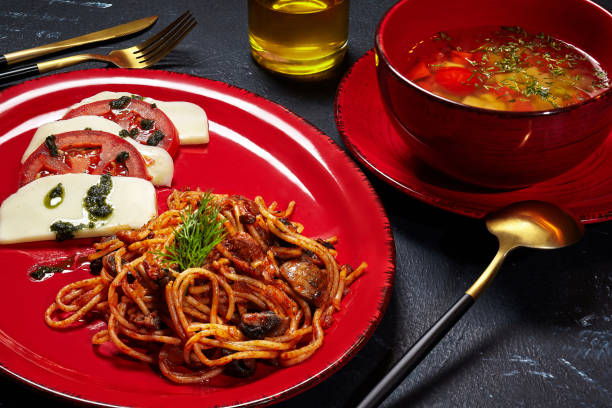 istock Set lunch from vegetable broth, spaghetti with mushrooms and Caprese salad 1331486122