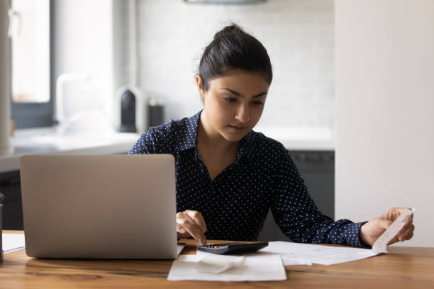 istock Focused millennial Indian woman counting budget, checking financial documents 1331487035