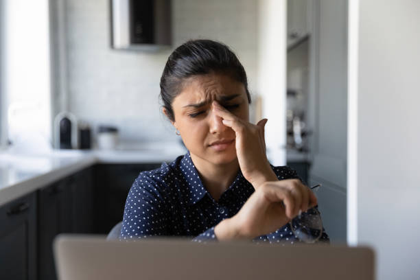 Sad distant worker taking off glasses, rubbing dry irritable eyes