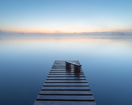 Tranquil sunrise and foggy lake