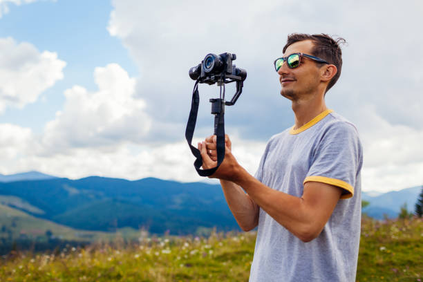 istock Videographer filming Carpathian mountains landscape. Man using steadicam and camera to make footage. Video shoot 1331487566