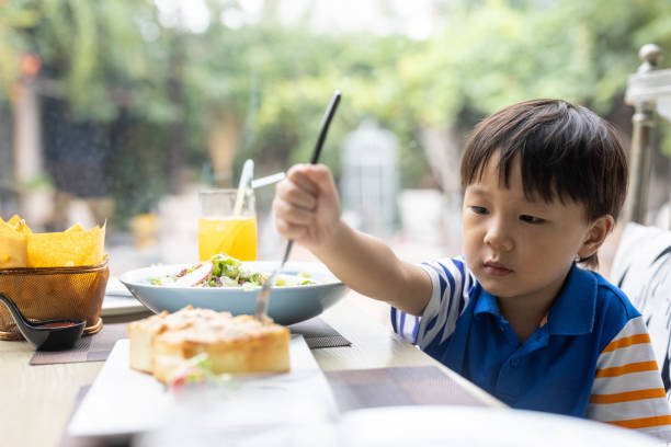 istock A little boy eating in a restaurant 1331488190