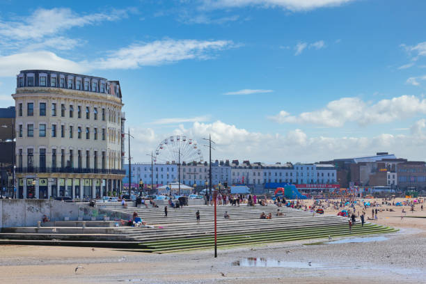 Margate sea front and main sands July 2021, Margate, Thanet, Kent, England, UK - crowds of tourists enjoying summer sunshine on the sea front and main beach in the seaside resort of Margate. The Big Wheel fairground ride at Dreamland and Margate Clock Tower can also be seen in the distance. thanet photos stock pictures, royalty-free photos & images