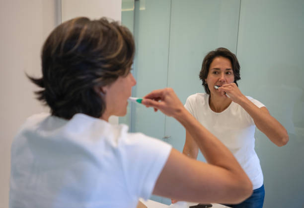 istock Woman at home in the bathroom brushing her teeth 1331490700