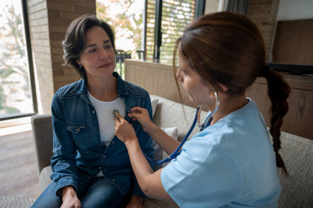 istock Nurse visiting a patient at home and checking her heart with a stethoscope 1331490745