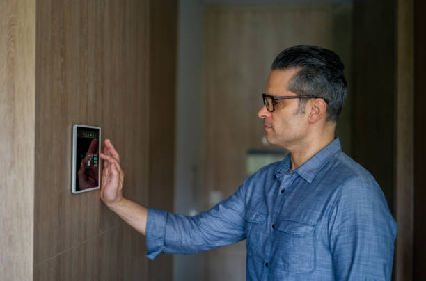 istock Man locking the door of his house using a home automation system 1331490834