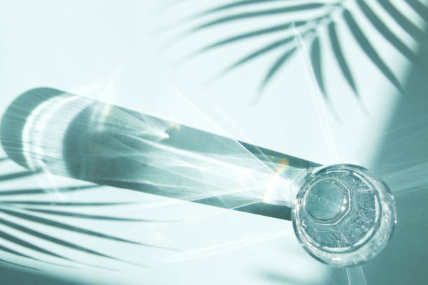 istock Trendy pattern made with glasses and shadows on blue background. Sunlight through glass of water, palm tree leaf shadows. 1331491972