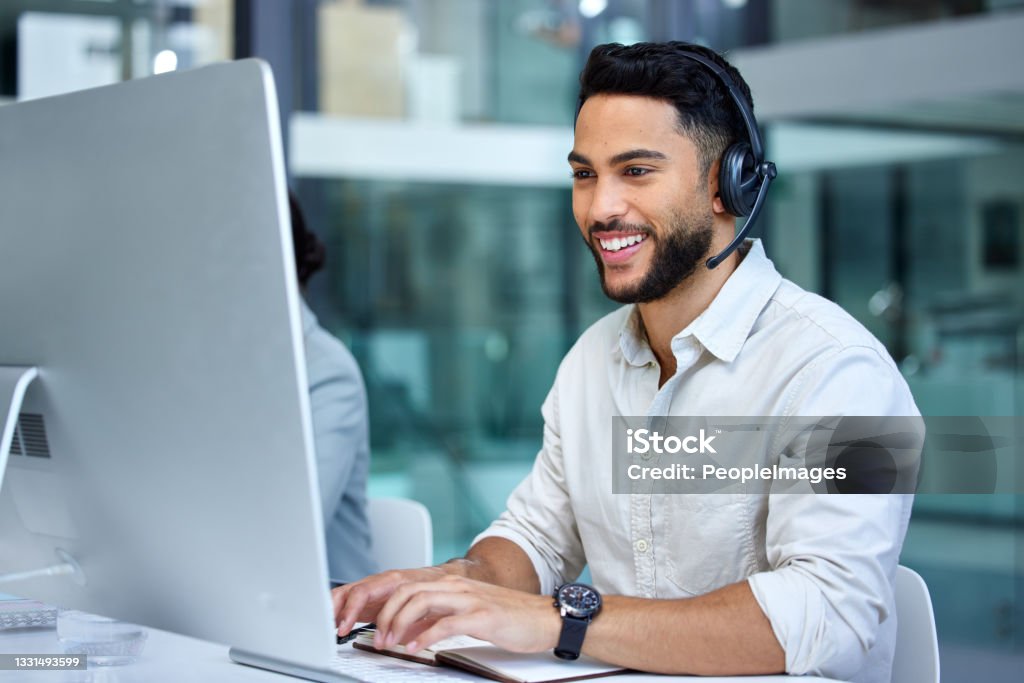 Shot of a businessman using a computer while working in a call center He answers all calls with skill and clarity Service Stock Photo