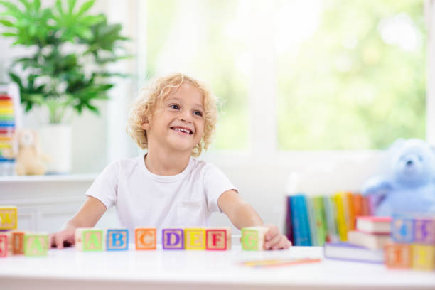 istock Child learning letters. Kid with wooden abc blocks 1331499273