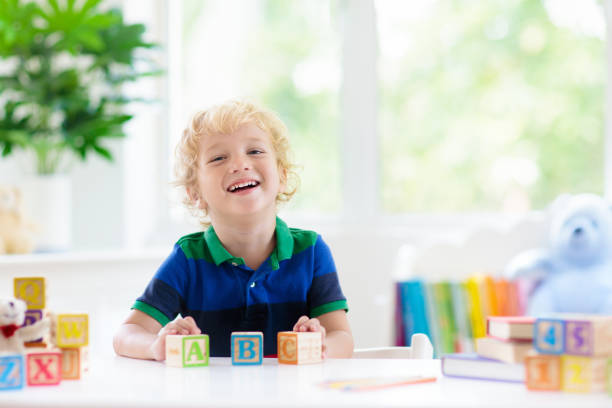 istock Child learning letters. Kid with wooden abc blocks 1331499294