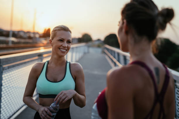 istock Women exercising together outdoors in summer evening and relaxing after training 1331499534