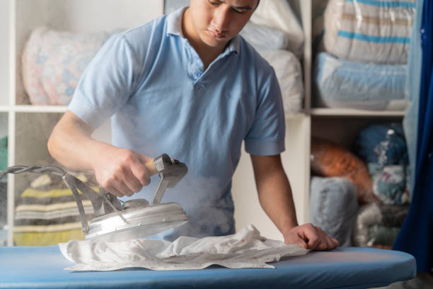 istock Laundry worker male steam ironing a shirt 1331506363