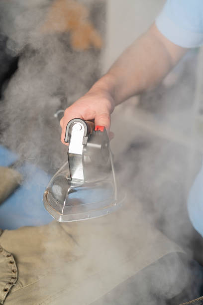istock Close-up of a laundry worker's hands steam ironing a jacket 1331506374