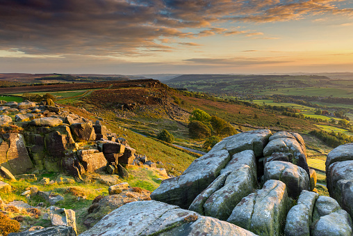 Wide angle view of the sun rising over Curbar Edge in the Peak District National Park, Derbyshire, England, UK.