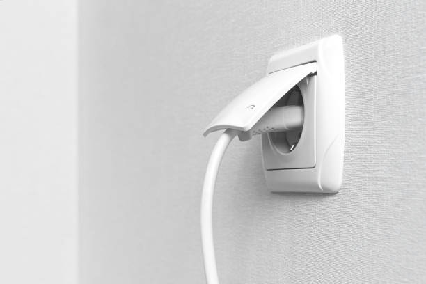 istock White electrical plug in the electric socket on a wall, interior photo 1331509636