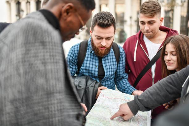 istock Tour Guide Pointing For Group To Destination On Map 1331514242