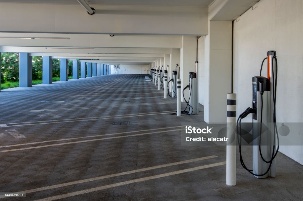 Parking Garage with Chargers Parking garage with electrical charging stations. Electric Vehicle Charging Station Stock Photo