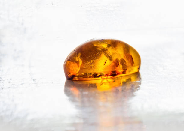 Amber stone with surface reflection, Sunstone isolated on white background.