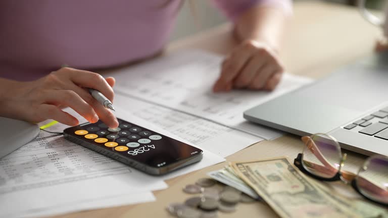 Close up female hands using calculator calculates expenses