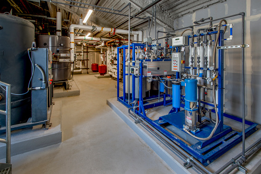 Boiler room with insulated pipes and water softener.