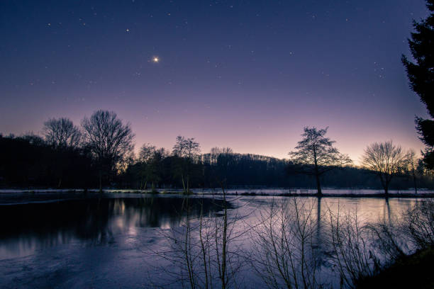 crepuscolo alla sera d'inverno con stelle e venere sul cielo notturno nel paesaggio lacuscerio con sagome alberi e riflessi - spring forest scenics reflection foto e immagini stock