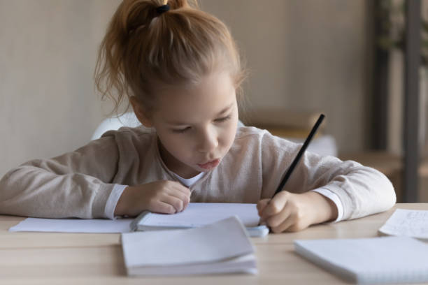 istock Little preteen girl study foreign language writing classwork at desk 1331541084