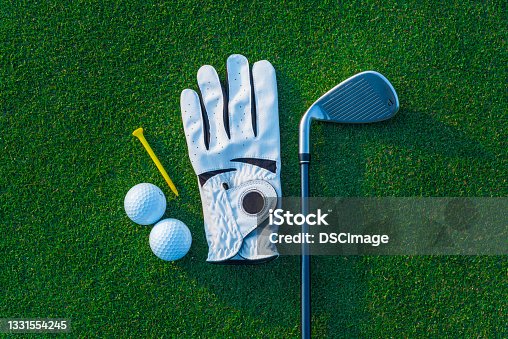 istock Golf glove ,colorful ball ,tee and gold club put on green grass of golf course ,This objects for play 1331554245