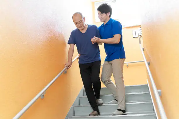 Photo of Elderly people going down the stairs with assistance