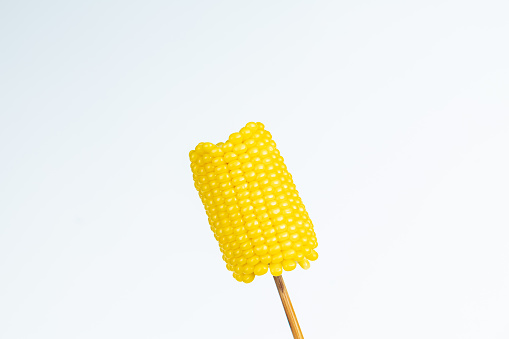 Corn skewered with chopsticks on white background
