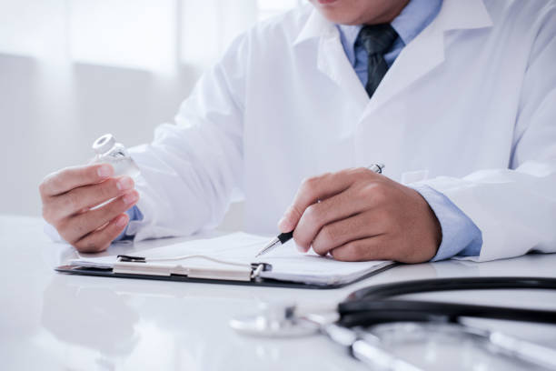 istock Doctor doing paperwork and using laptop in clinic. description into a server computer in hospital. Concept invented a cure, vaccine for coronavirus disease (COVID-19). 1331569243