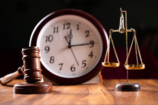 Concept showing of Problems with legal system, delay or slow in judicial justice system by using judge hammer, balance scale and wall clock