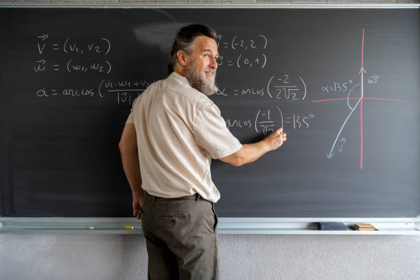 reifer kaukasischer gymnasiallehrer schreibt mathematikformeln mit kreide an die tafel. speicherplatz kopieren. - blackboard writing chalk teacher stock-fotos und bilder