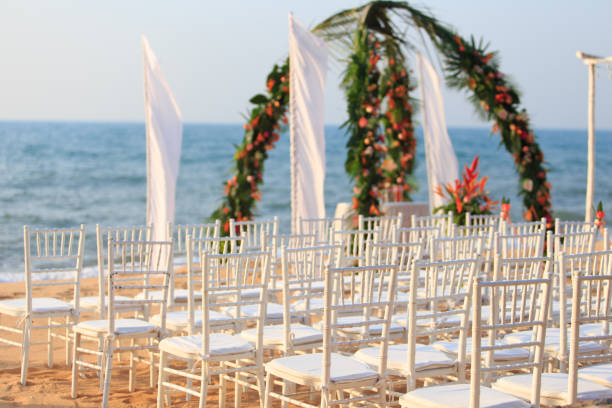 istock The beautiful setting for a wedding ceremony : white chairs and the square arch decorated with fresh flowers on the beach. 1331576170