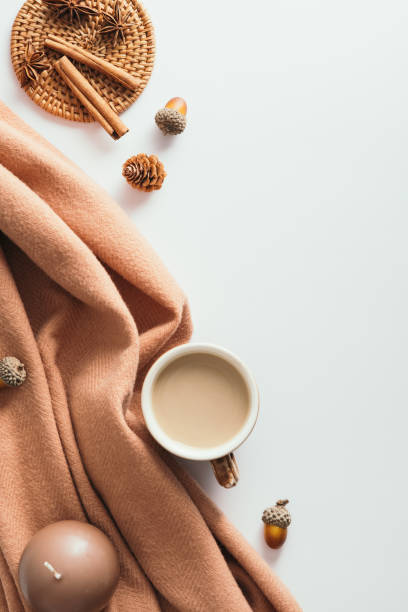 istock Autumn composition. Cup of coffee, brown blanket, acorns, cinnamon sticks on white background. Flat lay, top view. 1331582169