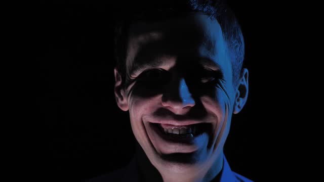 Man in the dark with creepy smile