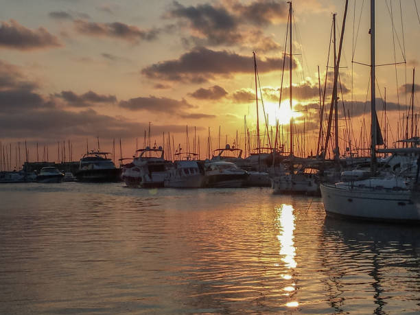 Sailing ships in port at sunset with red sky