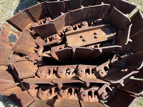 Top-down colour landscape photo of rusty dozer tracks sitting on the ground
