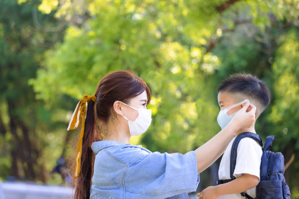 istock Mother help her son wearing medical mask for protection 1331589943