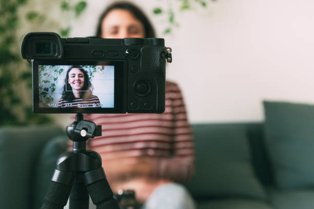 istock Girl recording herself with a camera at home. Selective focus on camera. 1331592288
