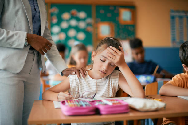 istock Tired schoolgirl having a headache during a class in the classroom. 1331594906
