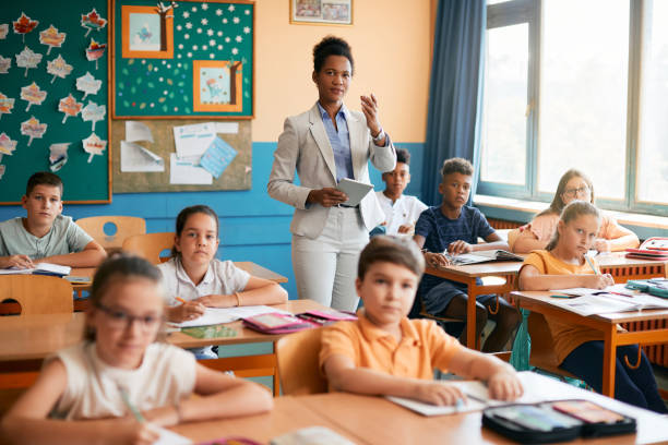 istock African American teacher giving a lecture to her students at elementary school. 1331594920