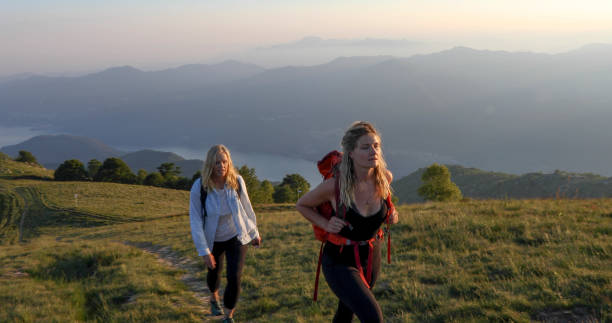 istock Two women hike through a mountain meadow at sunst 1331603268